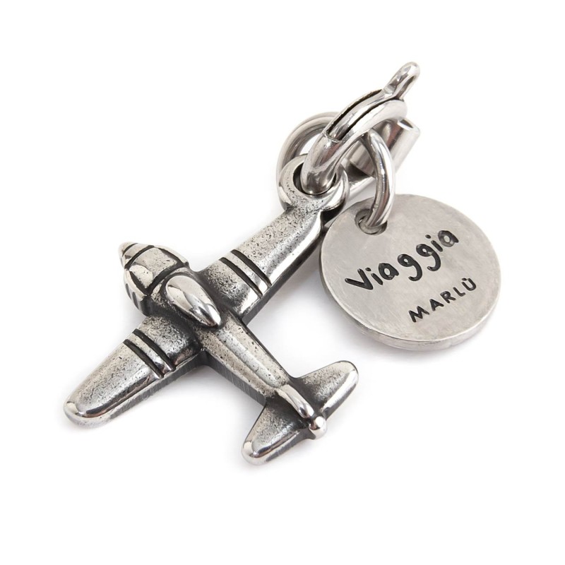 BURNISHED STEEL AIRPLANE CHARM Burnished steel charm in the shape of an airplane 14.80 x 16 mm and a round tag with the word "Vi BURNISHED STEEL AIRPLANE CHARM Burnished steel charm in the shape of an airplane 14.80 x 16 mm and a round tag with the word "Vi